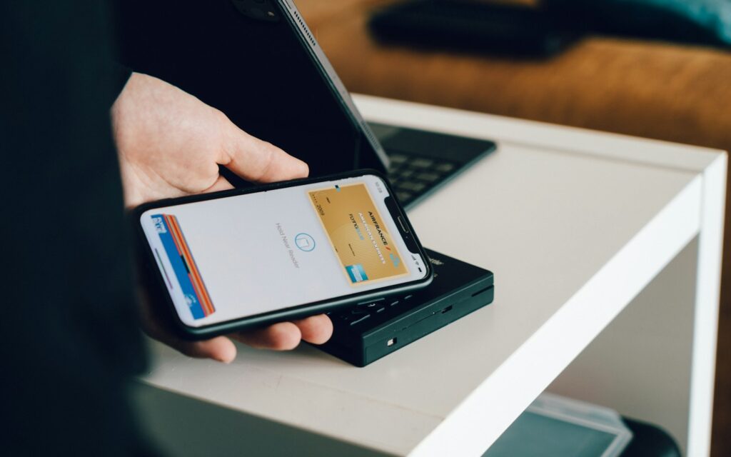 Kunde bezahlt kontaktlos mit dem Smartphone an einem mobilen Kartenleser