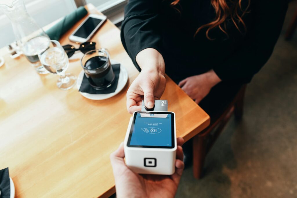 Verkäuferin hält eine mobile Kasse mit Kartenleser in der Hand