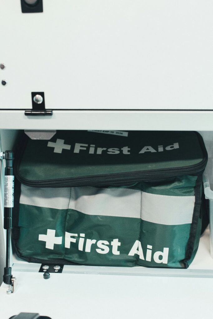 Grüne Erste-Hilfe-Tasche in einem weißen Schrank am Arbeitsplatz