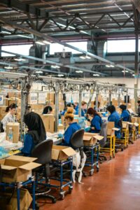 Mitarbeitende an einem Fließband in einer Fabrik, wo der Product Footprint eines Produkts maßgeblich entsteht