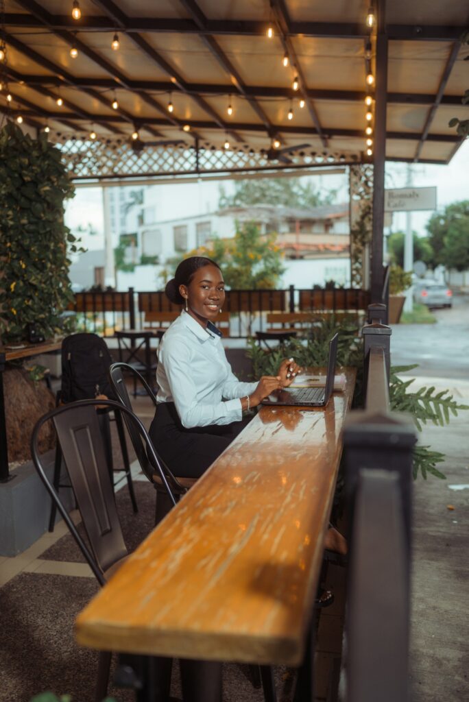 Gründerin arbeitet im Outdoor-Café am Laptop, wo ein VPN das öffentliche WLAN absichert