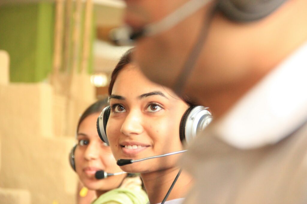 Zwei Supportmitarbeiterinnen mit Headsets übernehmen Anfragen vom Chatbot