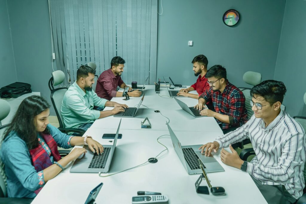Gruppe junger Fachkräfte arbeitet mit Laptops an einem Tisch als Symbolbild für Fachberufe 2026