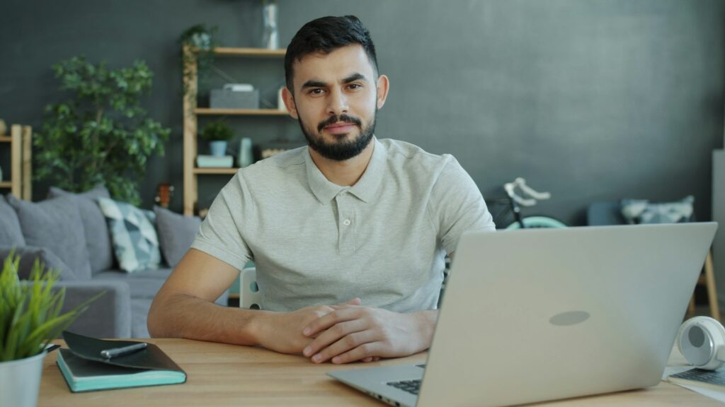 Gründer am Schreibtisch mit Laptop prüft die Zahlen der ersten Monate nach der Gründung
