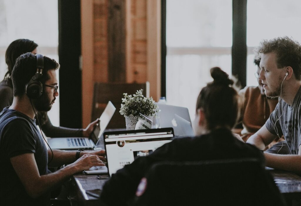Gründerteam sitzt am Tisch und plant gemeinsam Werbung für Startups