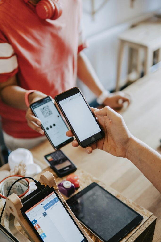 Zwei Personen halten Smartphones, um per Wero Geld in Echtzeit zu senden