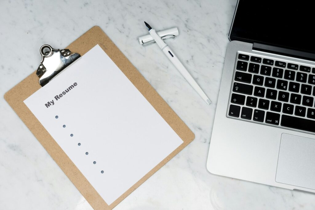 Firma gründen Kosten: Checkliste auf dem Klemmbrett neben dem Laptop