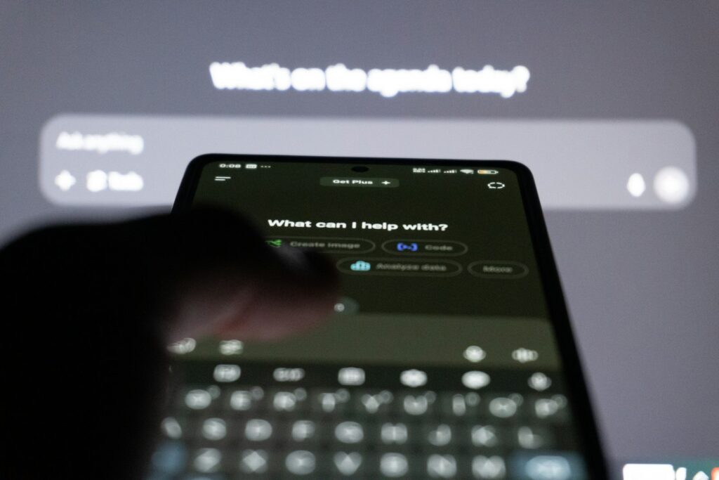 Person tippt auf dem Smartphone eine Frage in einen KI-Assistenten – Startups in Chatbots sichtbar machen
