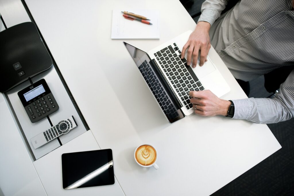 Steuern als Selbstständiger: Taschenrechner, Laptop und Belege auf dem Schreibtisch